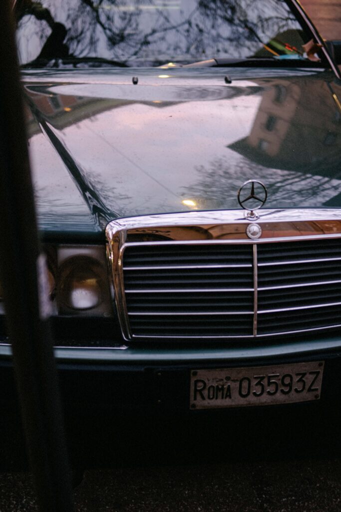 Vintage Mercedes Benz in pink evening light with a Roma license plate.